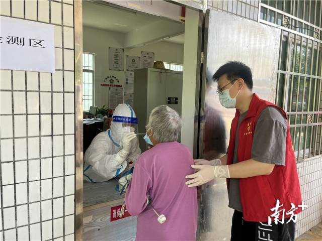 現(xiàn)場(chǎng)志愿者幫助行動(dòng)不便群眾接受核酸檢測(cè)。